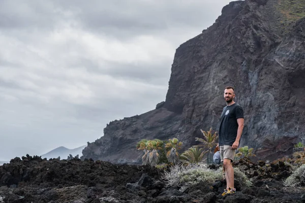 Caucásico Joven Guapo Hombre Pie Las Rocas Negras Día Nublado — Foto de Stock