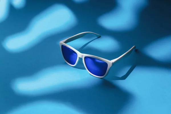 Verleih Einer Blauen Sonnenbrille Auf Blauem Hintergrund Einer Schattenszene Mit — Stockfoto