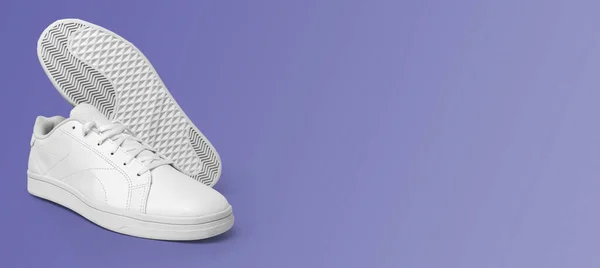 Banner with new pair of white sneakers isolated on purple (very peri) background. Sportive pair of shoes for mockup. Fashionable stylish sports casual shoes.