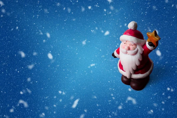 快乐的圣诞老人带着一颗金色的星星 蓝色雪白的背景 还有复制的空间 蓝色雪地背景下圣诞老人的圣诞装饰品 带有复制空间 — 图库照片