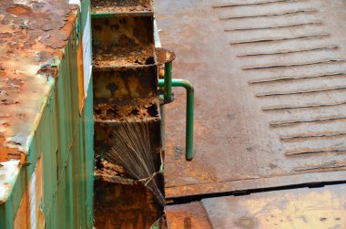 Eski paslı, delikli metal boru.