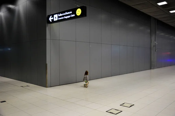 a child wandering around an airport hall. Alone in the airport hall.