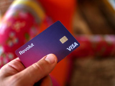 Wallers, Fransa - 08032022: Bulanık renkli bir arkaplanda bir adamın elinde tuttuğu Revolut ödeme kartı
