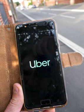 Akıllı telefon Uber uygulaması ile açıldı, beyaz bir erkek tarafından tutuluyor..