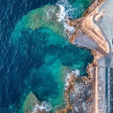 Cirkewwa dalış alanı, kayalık kıyı şeridi ve gün batımında mavi renkler, Malta