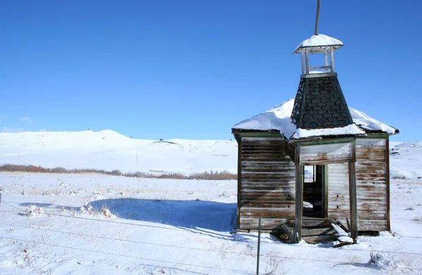 abandoned one room school house in snowy winter scene