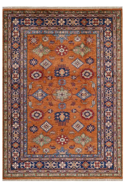 Arka planda el yapımı Afgan halısı var.