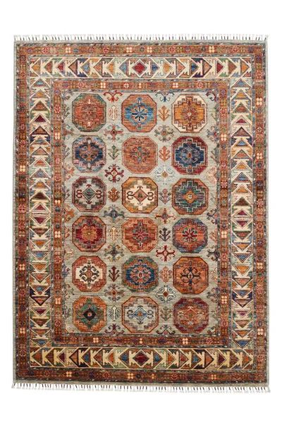 Arka planda el yapımı Afgan halısı var.