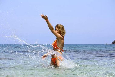 Kadın denize su fırlatır, su sıçratır..