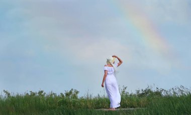 Beyazlı kadın, gökkuşağının altında..