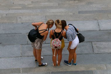 Üç turist kız garip bir şekilde telefon izliyor..