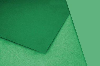 Düz ve desenli yeşil kağıtlar, yaratıcı kapak tasarımı fikri için M şeklinde gelişigüzel dizayn ediliyor.