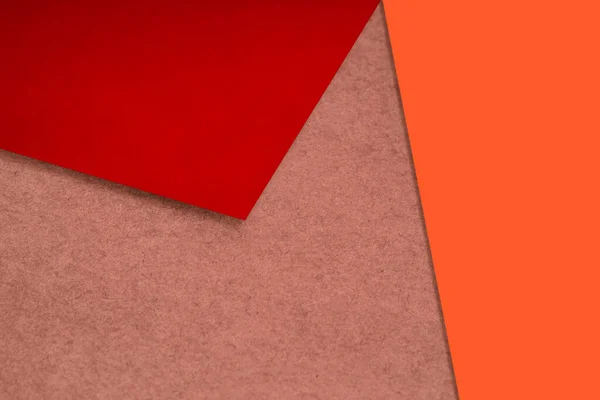 Plain and Textured neon orange red brown papers randomly laying to form M like pattern and triangle for creative cover design idea