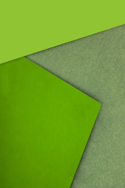 Plain and Textured neon green yellow brown papers randomly laying to form M like pattern and triangle for creative cover design idea