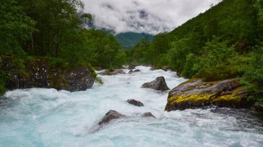 Güçlü nehirler tarafından kıyıya vuran kayalar suları, sisli dağları, Trollstigen, Norveç, İskandinavya, Avrupa 'da yağmurlu yaz günlerini.