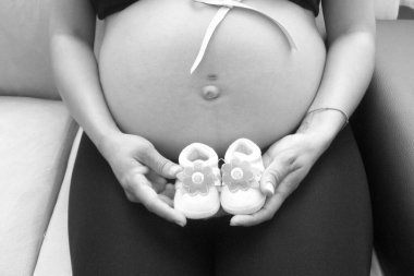 Mujer embarazada con zapatos de bebe