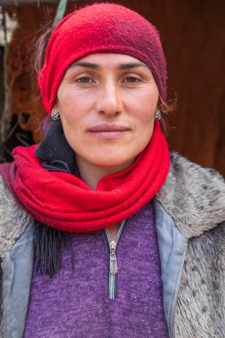 Gorno-Badakhshan Özerk Bölgesi, Tacikistan. 14 Ağustos 2021. Tacikistan dağlarında kırmızı başörtüsü takan bir kadın..