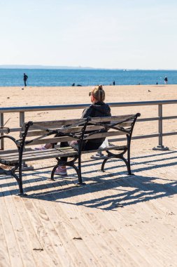 Coney Adası, Brooklyn, New York, New York, ABD. 6 Kasım 2021. Coney Island plajında okyanusa bakan bir kadın..