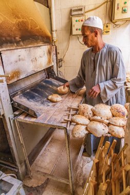 Teb, Luxor, Mısır. 24 Şubat 2022. Baker otomatik fırından pita ekmeği yapıyor..