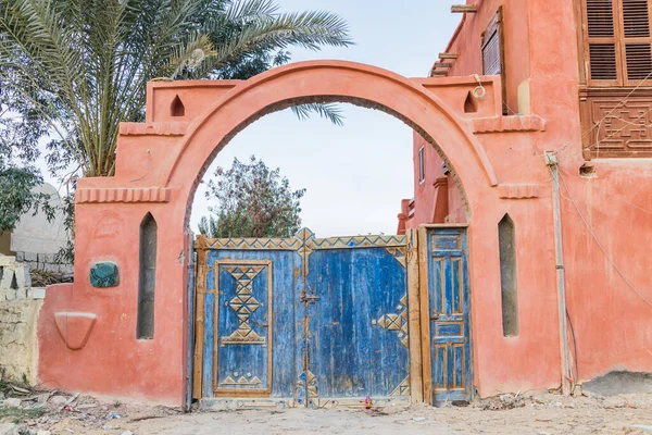 Faiyum, Egypt. Blue painted wooden gate in a wall in the village of Faiyum.