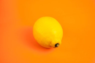 Turuncu arka planda tek bir limon