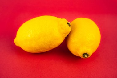 Kırmızı arkaplanda bir çift limon