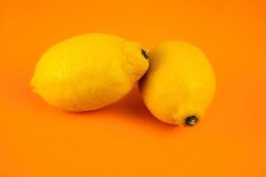 Turuncu arka planda bir çift limon