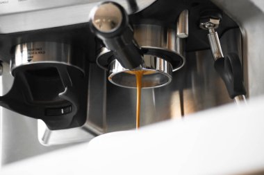 Kahve makinesinden kahve dökülüyor.