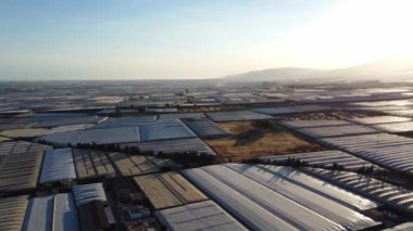 El Ejido 'daki seraların panoramik drone görüntüsü. Endülüs dağlarının arkasında güneş batıyor. Yüksek kalite 4k görüntü