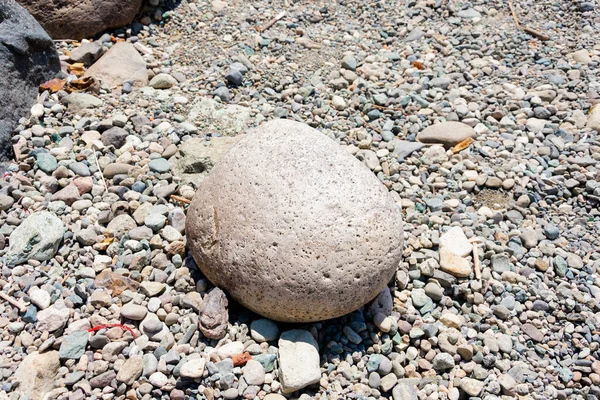 A big stone and many small stones around it. Nahuel Huapi Lake. Bariloche, Argentina