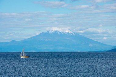 Puerto Varas, Şili. 13 Şubat 2020. Llanquihue Gölü 'ndeki ahşap bir tekne manzarası ve arka planda Osorno volkanı.