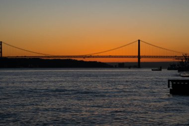 Tagus Nehri (Rio Tajo) ve 25 Nisan Köprüsü 'nün (Ponte 25 de Abril) günbatımı manzarası. Lizbon, Portekiz