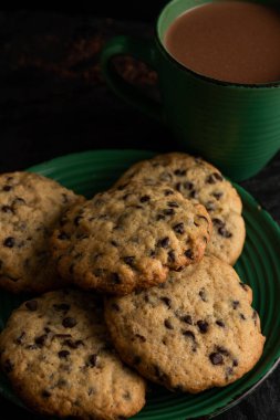 Bir kupa ev yapımı kurabiyeyi siyah ahşap arka planda kapat.