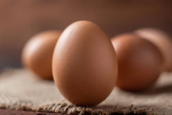 chicken egg in a wooden box on a brown background.