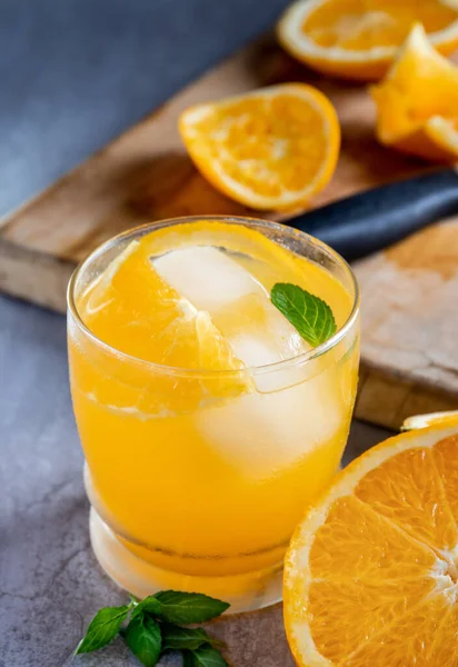 fresh orange juice with mint leaves and lemon slices on a wooden table. copy space, top view.