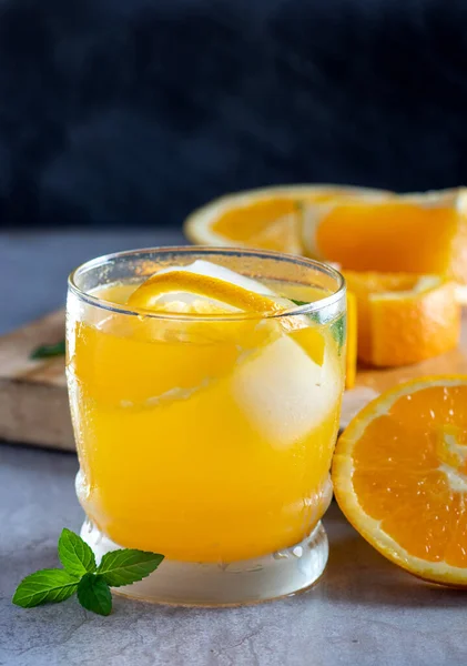 fresh orange juice with lemon and mint on a wooden background.