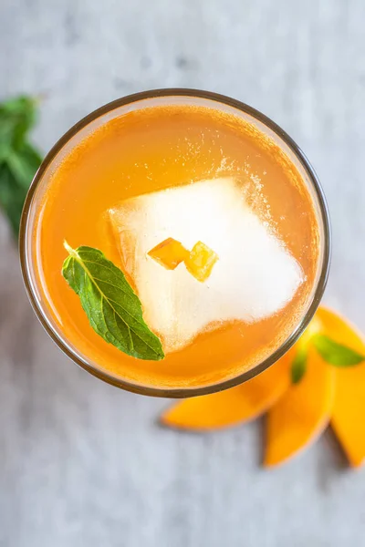 Orange juice with mint and ice. top view