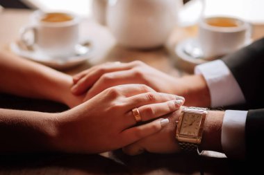 Yüzüklü yeni evlilerin elleri. Aşıkların şefkatli duyguları. Yüksek kalite fotoğraf