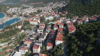 Türkiye 'de deniz kıyısındaki küçük bir kasabanın çatılarında bir dron uçuyor. Yunan adalarına yakın