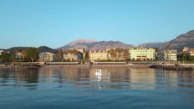 İnsansız hava aracı denizdeki ıssız bir rıhtımın üzerinden uçuyor, rıhtımda güneşlikler var. Şafak, Türkiye, Kemer şehri