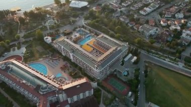 Türkiye 'nin Kemer kentinin havadan görüntüsü. Sakin bir turistik otelde gün doğumu vakti. Dağların panoramik manzarasıyla çevrili bir turistik tesis. Temiz su ve sahil