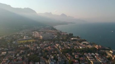 Dağlarla çevrili deniz kıyısında şafak, dağlarda sabah sisi, Türkiye 4k