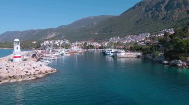 Şehrin yakınında dağlarla çevrili beyaz deniz fenerinin yanında bir körfez ve marina. Türkiye, 4k
