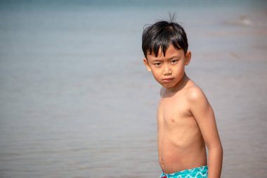 Çocuk sahilde durmuş, bir şeye bakıyordu..