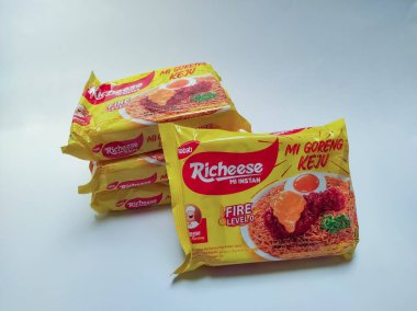 Jakarta, Endonezya - 24 Eylül 2022: Richeese markasından alınmış peynir aromalı hazır erişte ürünü ve 0 'dan 3. seviyeye kadar baharatlı, beyaz renkte izole edilmiş.
