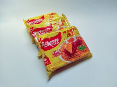 Jakarta, Endonezya - 24 Eylül 2022: Richeese markasından alınmış peynir aromalı hazır erişte ürünü ve 0 'dan 3. seviyeye kadar baharatlı, beyaz renkte izole edilmiş.