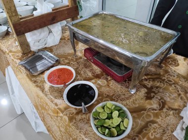 Yuvarlak bluzlu Coto Makassar ve kırmızı biber sosu, soya sosu, düğünde limon.