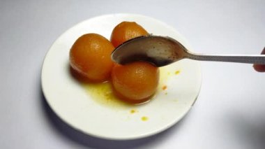 Gulabjamun 'u beyaz bir tabakta yakın plan çek. Bengali tatlı gulabjamun.