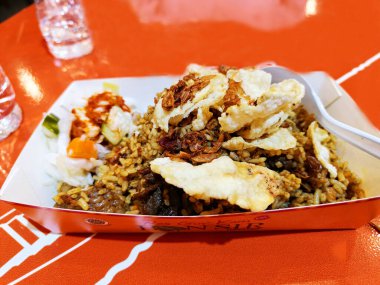 Yüksek açılı Endonezya usulü kızarmış pirinç ve karton tabakta servis edilen kuzu eti..