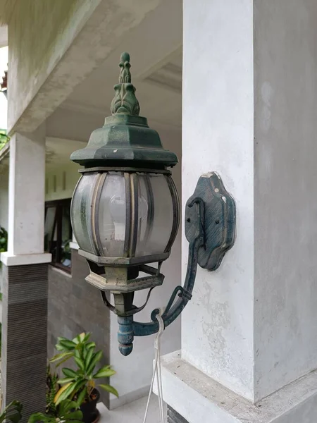 Rustic Vintage Green Garden Lanterns Home Decorate on the Wall with Nature Background. Rust Green Lamp hanging on the white wall.